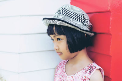 Portrait of a girl wearing hat against wall