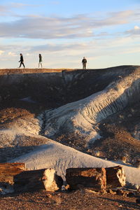 People standing on mountain against sky