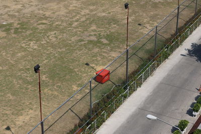 High angle view of fence by railing on footpath