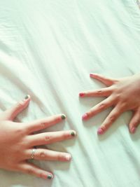 Close-up of woman hand on bed