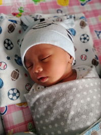 Portrait of cute baby boy sleeping on bed