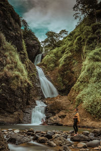 Scenic view of waterfall against mountain
