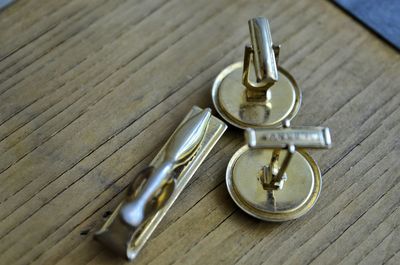 High angle view of cuff links on wooden table