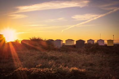 Scenic view of beach huts against cloudy sky