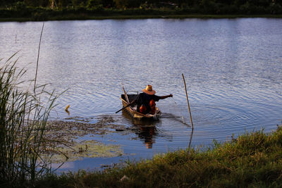 Rear view of man in boat on lake