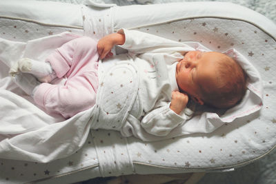 Newborn baby sleeps peacefully. gentle innocent baby lies, closeup portrait at home, top view