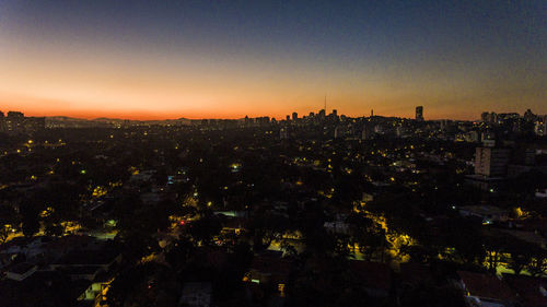 Illuminated cityscape against sky at night