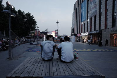 Rear view of people walking on street in city