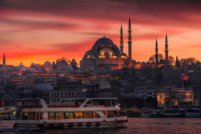 Buildings in city against sky during sunset