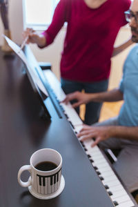 Man and woman using piano at home