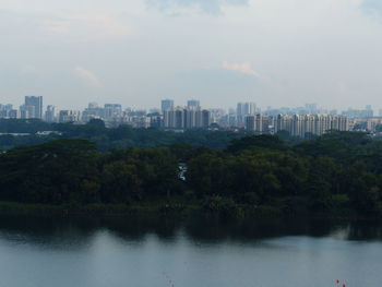 Scenic view of river by city against sky