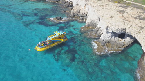 High angle view of people on rock by sea