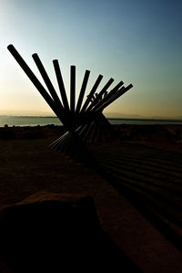 Scenic view of silhouette beach against sky during sunset