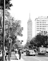 Cars on road in city against clear sky