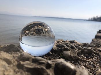 Close-up of crystal ball against sky