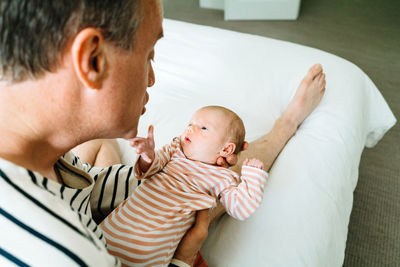 Cropped portrait of a dad holding his newborn daughter at home