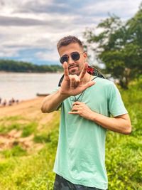 Young man wearing sunglasses standing on land