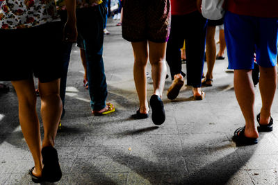 Low section of people walking on street