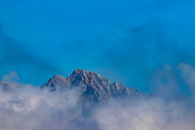 Low angle view of mountain against blue sky