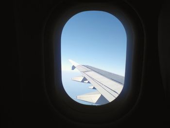 View of airplane wing against clear blue sky