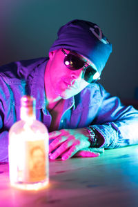 Portrait of man with drink sitting on table