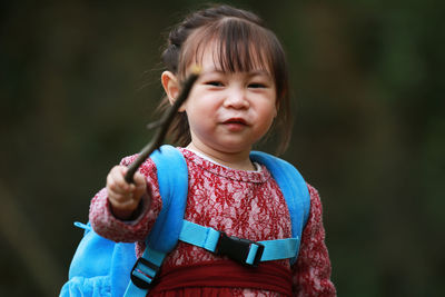 Portrait of cute girl holding stick