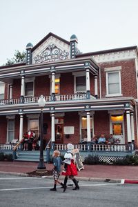 Rear view of man walking in front of historic building