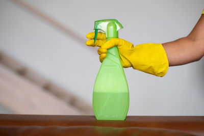 Close-up of hand holding yellow toy on table