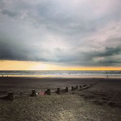 Scenic view of beach against dramatic sky