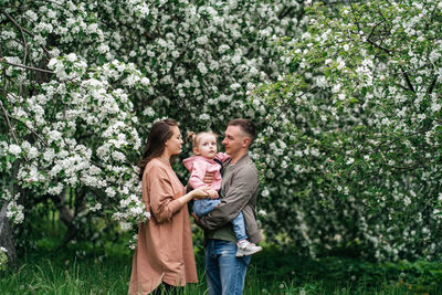 Family mom mom baby daughter in the garden blooming apple trees