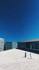 People on building against blue sky