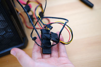 A man repairs a cable in a system unit and connects electrical wires