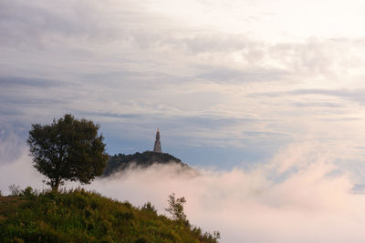 Low angle view of tower against cloudy sky