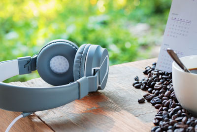 Close-up of headphones with roasted coffee beans on table