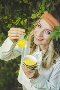 Portrait of smiling young woman holding drink