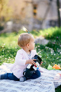 Boy holding toy sitting outdoors