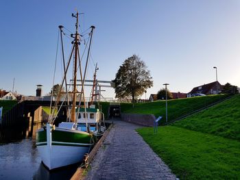 Boats moored at harbor against clear sky