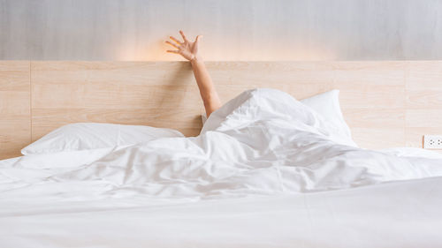 Midsection of woman lying on bed at home