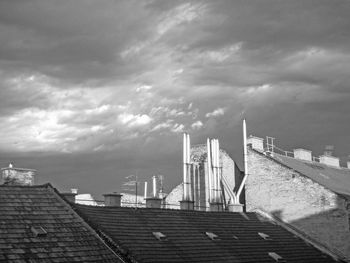 Buildings in city against cloudy sky