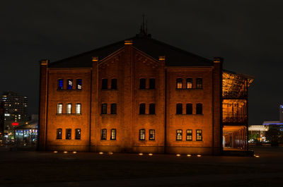 Illuminated building against sky at night