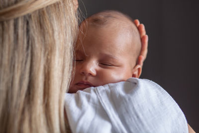 Close-up of mother with cute baby at home