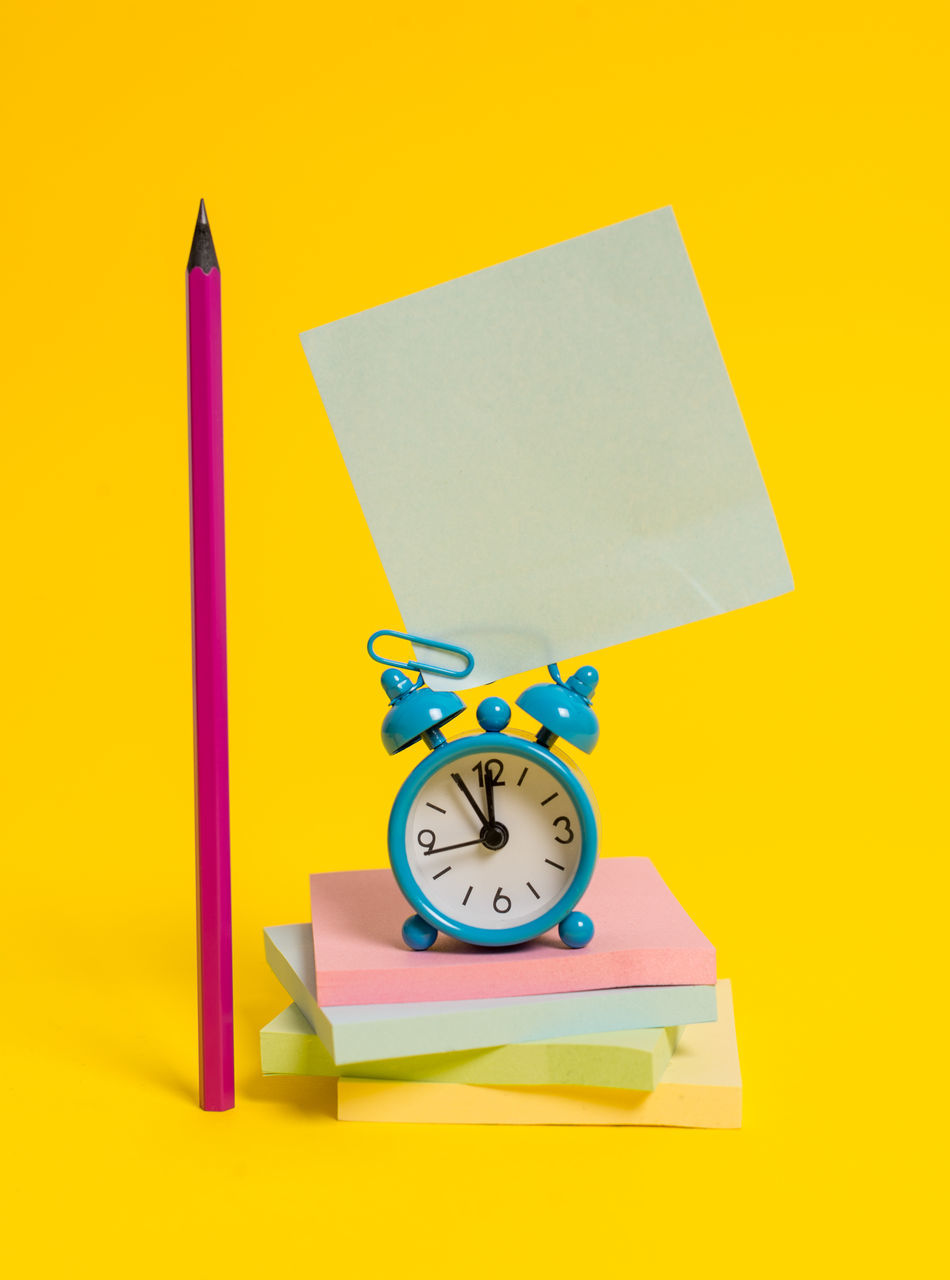 CLOSE-UP OF CLOCK ON YELLOW PENCIL