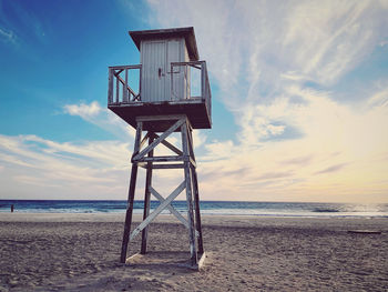 Lifeguard hut on beach against sky