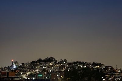 Illuminated cityscape against sky at night