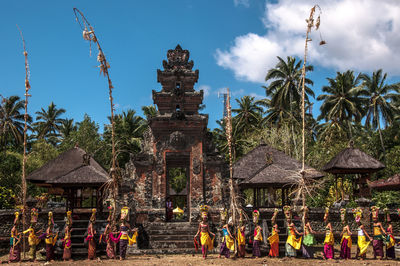 Group of people in traditional building against sky