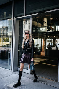 Portrait of young woman standing in city