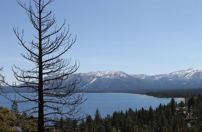 Scenic view of lake and mountains against blue sky