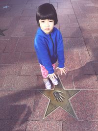 High angle of cute girl standing on footpath