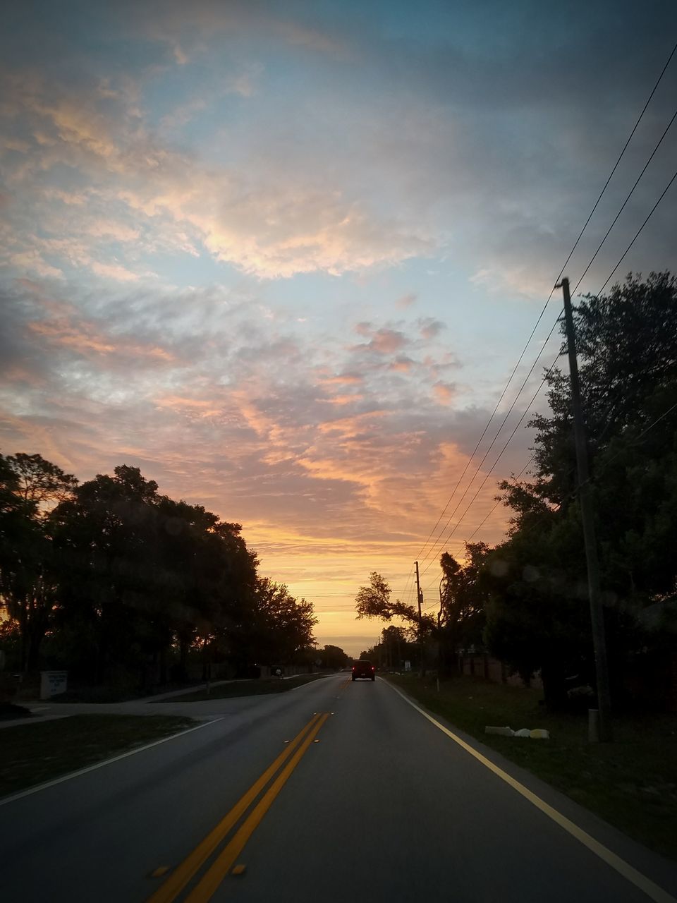 ROAD BY SILHOUETTE TREES AGAINST SKY AT SUNSET