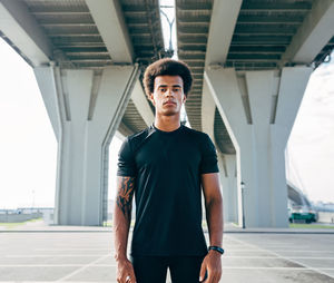 Portrait of young man standing against wall